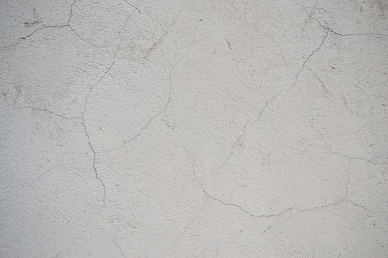 Hairline cracks in a white interior wall